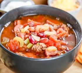 best slow cooker turkey chili, Slow Cooker Turkey Chili with ground turkey kielbasa beans tomato and celery in a black bowl