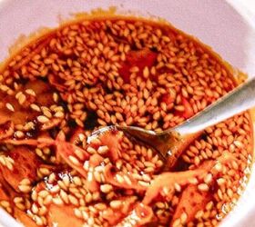 the best fireball apple cider drink for the fall season, Homemade garlic chili oil with sesame seeds and fried garlic slices in a white bowl