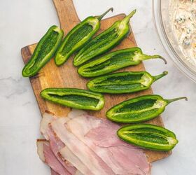 air fryer bacon wrapped jalapeno poppers, Sliced jalapeno peppers with the seeds removed and slices of bacon are on a cutting board