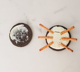 oreo spider cookies recipe for halloween parties, Open Oreo cookie with pretzel sticks arranged as spider legs on the cream filling