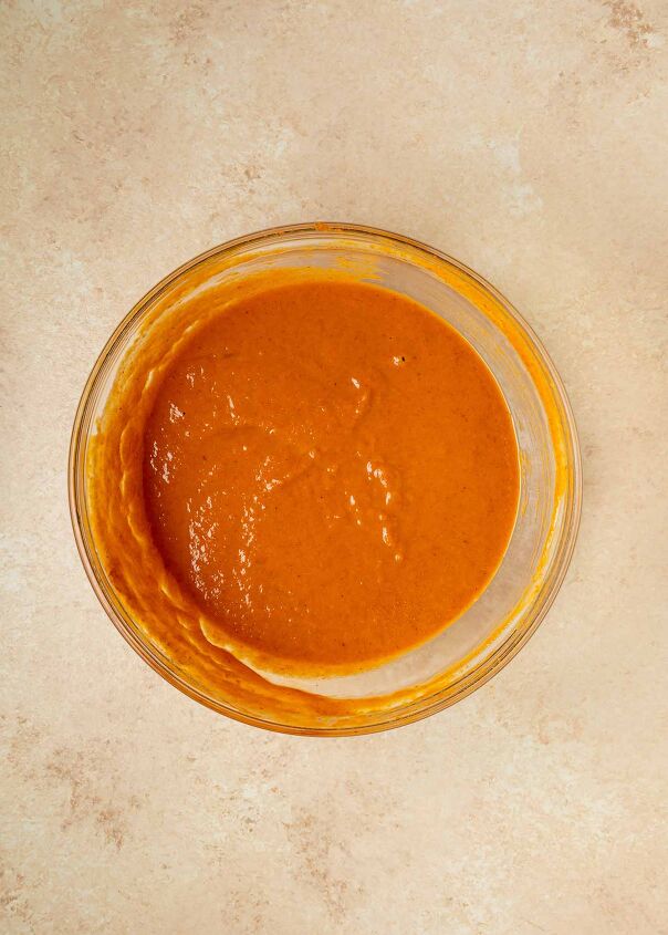 pumpkin dump cake, A glass bowl filled with thick smooth dump cake batter sits on a light beige textured surface
