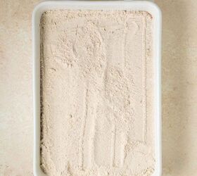 pumpkin dump cake, A white rectangular baking dish topped with cake mix with a lightly smoothed surface sits on a beige countertop