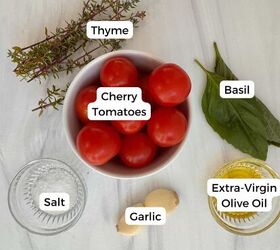 cherry tomato confit with basil and thyme mediterranean style, A bowl of cherry tomatoes is surrounded by thyme basil leaves a small glass dish of salt two garlic cloves and extra virgin olive oil classic Mediterranean ingredients for making cherry tomato confit neatly labeled on a white surface