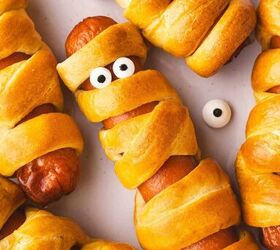 spooky cute air fryer mummy hot dogs kids will love, Close up of a golden Air Fryer Mummy Hot Dog showing crescent roll bandages and candy eyes