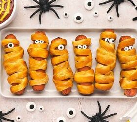 spooky cute air fryer mummy hot dogs kids will love, Spooky Halloween mummy hot dogs arranged on a serving platter with ketchup and mustard in a spider web pattern