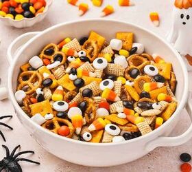 spooky halloween snack mix easy kid friendly recipe, Festive Halloween snack mix overflowing from a large ceramic bowl on a table