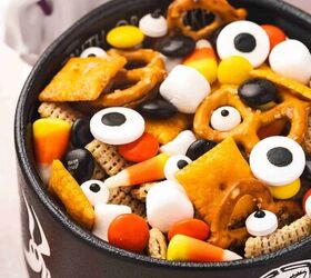spooky halloween snack mix easy kid friendly recipe, Close up of Halloween Chex and Cheez Its snack mix in a black Halloween bowl with candy corn and candy eyes