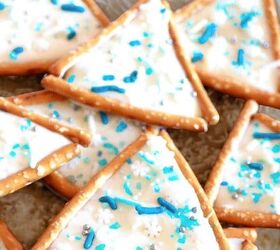 pumpkin cheesecake brownies recipe for fall desserts, Triangle pretzel Christmas tree cookies decorated with white icing blue sprinkles and snowflake candy on parchment paper