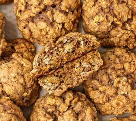 pumpkin oatmeal cookies, A close up view of several pumpkin oatmeal cookies on parchment paper with one cookie broken in half to show its chewy textured interior