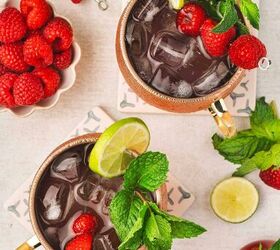 easy raspberry moscow mule party ready mint cocktail, Copper mug filled with Raspberry Moscow Mule surrounded by fresh raspberries and lime