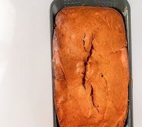 perfectly moist cream cheese pumpkin bread recipe, Baked cream cheese pumpkin bread in the loaf pan on a white surface ready to slice