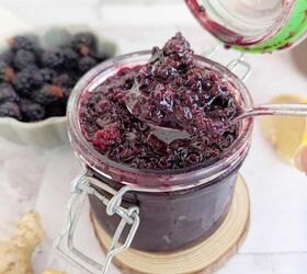 chunky blackberry compote with fresh ginger, An open jar of blackberry ginger compote Blackberries are faded in the backgroung and ginger by the side