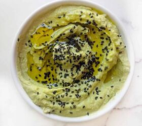 easy creamy all in one avocado chickpea hummus, A white bowl of avocado hummus topped with a drizzle of olive oil and sprinkled with sesame seeds