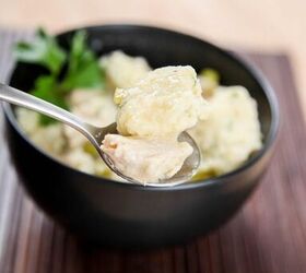 best instant pot chicken and dumplings, a spoon lifting out a bite of chicken and dumplings