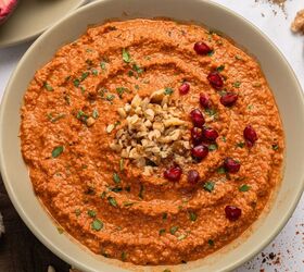 muhammara recipe roasted red pepper dip gf, A bowl of muhammara dip made from a classic muhammara recipe garnished with chopped walnuts parsley and pomegranate seeds displayed on a light colored plate against a white background