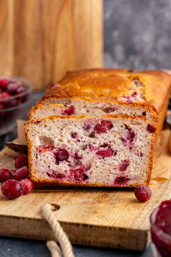 cranberry sauce bread, Cranberry Sauce Bread on a cutting board with frozen cranberries around