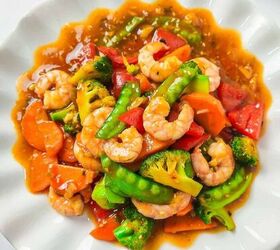 homemade shrimp and vegetable stir fry in 30 minutes, A colorful shrimp stir fry served on a white scalloped plate featuring plump shrimp bright broccoli florets snow peas carrots and red bell peppers coated in a glossy savory sauce