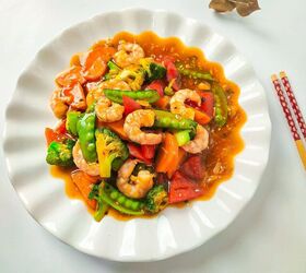 homemade shrimp and vegetable stir fry in 30 minutes, Overhead shot of shrimp and vegetable stir fry on a white scalloped plate styled with chopsticks on the side
