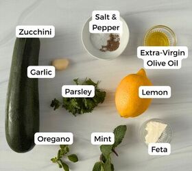 mediterranean roasted zucchini slices, Roasted zucchini slices garlic clove parsley oregano mint lemon feta cheese and extra virgin olive oil are arranged on a light gray surface with labels for each ingredient alongside a bowl of salt and pepper
