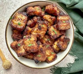air fryer pork belly crispy bites, Air fried pork belly bites in a serving bowl with a teaspoon of brown sugar and green towel on the countertop