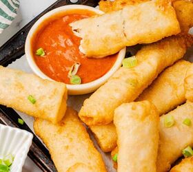 buffalo chicken egg rolls air fryer recipe, Buffalo chicken egg rolls on a serving platter with one dripping into a bowl of buffalo sauce