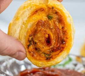 buffalo chicken egg rolls air fryer recipe, A hand dipping a pepperoni pizza pinwheel in marinara sauce