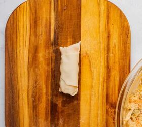 buffalo chicken egg rolls air fryer recipe, Egg roll tightly wrapped on a wooden cutting board