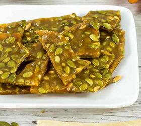 best pumpkin seeds brittle sweet nutty crunchy, Close up of shiny pumpkin seed brittle on a white platter showing glossy caramel coating