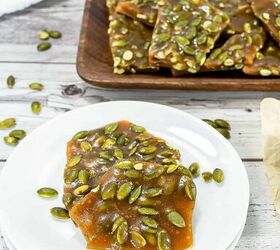 best pumpkin seeds brittle sweet nutty crunchy, Pumpkin seed brittle pieces on a white plate with more brittle on a wooden tray in the background