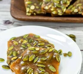best pumpkin seeds brittle sweet nutty crunchy, Stack of pumpkin seed brittle squares on parchment paper with fall floral decor in the background