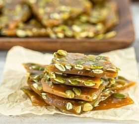 best pumpkin seeds brittle sweet nutty crunchy, Stacked pumpkin seed brittle pieces on parchment paper showing glossy texture and toasted pepitas