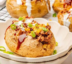 loaded baked potato with brisket, A loaded baked potato with brisket BBQ sauce cheese and sour cream on a plate