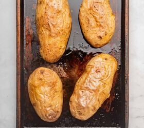 loaded baked potato with brisket, Four baked potatoes on a sheet pan with crispy skin