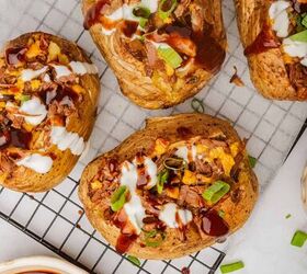 loaded baked potato with brisket, Four loaded brisket baked potatoes on a cooling rack with BBQ sauce cheese and sour cream