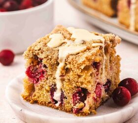 the best cranberry orange coffee cake with crunchy streusel, Slice of cranberry orange coffee cake on a white plate with orange slices on the side
