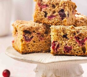 the best cranberry orange coffee cake with crunchy streusel, Cranberry orange coffee cake cut into squares with glaze drizzled on top