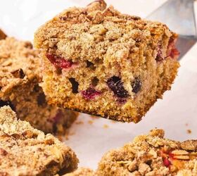 the best cranberry orange coffee cake with crunchy streusel, Moist cranberry orange coffee cake slice on a plate drizzled with yogurt glaze