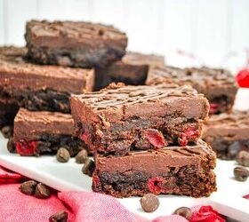 cherry brownies, cherry brownies topped with chocolate ganache on a platter with chocolate chips scattered around