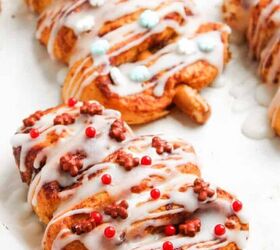 cute and easy marshmallow snowmen for the holidays, Festive cinnamon roll Christmas tree pastries decorated with icing and colorful sprinkles on a baking tray holiday dessert idea