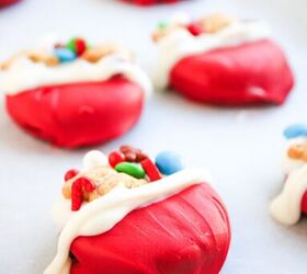 easy christmas oreos santa s toy bag oreos recipe, A close up view of a red and white dipped cookie decorated with holiday candies and teddy bear crackers