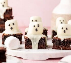 halloween brownies easy ghost brownies, Fudgy chocolate brownies cut into squares topped with white marshmallow ghosts and candy eyes on a marble tray