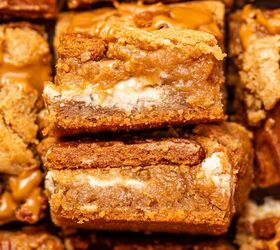 biscoff blondies with white chocolate cookie butter, Soft chewy biscoff blondies stacked on top of each other showing gooey texture