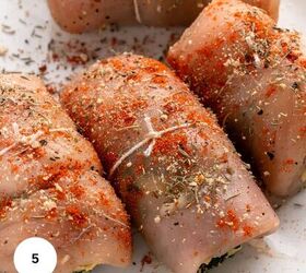 easy chicken roulade recipe with spinach sundried tomatoes gf, Four uncooked chicken roulade breasts rolled and tied with string seasoned with herbs and paprika are arranged on a white surface A white circle with the number 5 appears in the lower left corner of the image