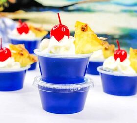 malibu jello shots, blue malibu rum jello shots topped with whipped cream pineapple and a cherry