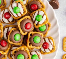 pretzel christmas treats, Christmas Pretzel Treats stacked on a plate close up with M Ms pretzel snaps and Hersheys chocolates in the back