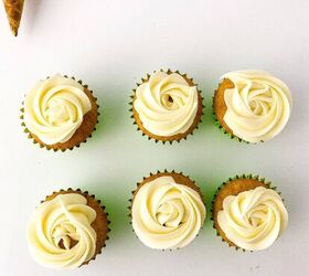 easy christmas tree cupcakes to brighten holidays, Six cupcakes topped with white buttercream rosettes arranged neatly on a white surface with decorating tools nearby