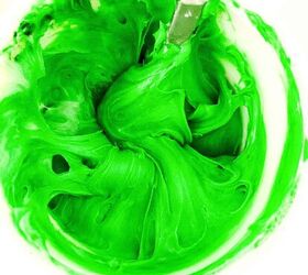 easy christmas tree cupcakes to brighten holidays, Bright green frosting swirled in a bowl after mixing with green food coloring for Christmas tree cupcakes