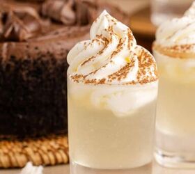 chocolate cake shot, Chocolate Cake Shot in Shot Glasses and Garnished with Whipped Cream and Cocoa Powder with Chocolate Cake in Background