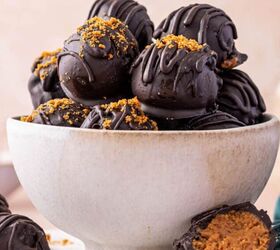 christmas crunch recipe easy holiday snack mix, No bake Biscoff truffles on a white bowl coated in dark chocolate and drizzled with melted chocolate for a festive look One truffle being cut opened