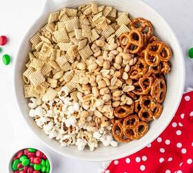 christmas crunch recipe easy holiday snack mix, Overhead shot of bowl filled with mix of pretzels M Ms peanuts chex cereal etc